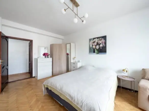 Bright, stylish bedroom in a Tallinn apartment with contemporary furnishings and floral artwork.