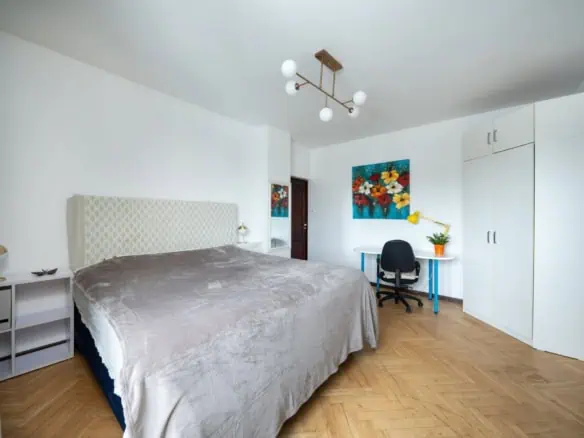 Bright, stylish bedroom in Tallinn with queen bed, workspace, and artistic decor.