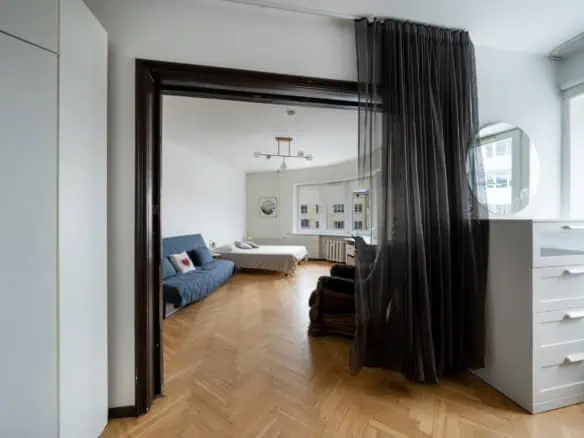 Bright, stylish hotel room featuring a large window, cozy bed, and contemporary decor in Tallinn.