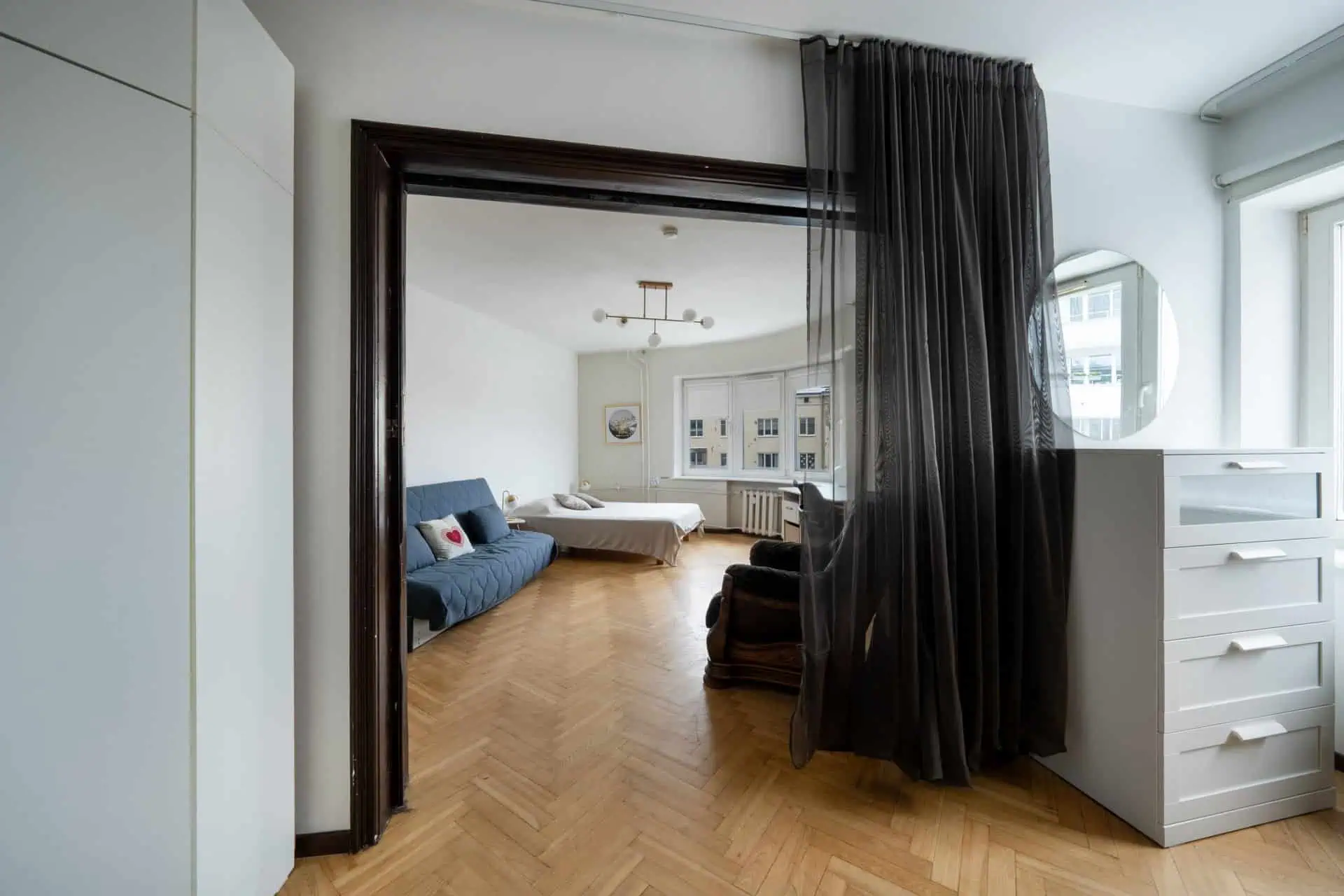 Bright, stylish hotel room featuring a large window, cozy bed, and contemporary decor in Tallinn.