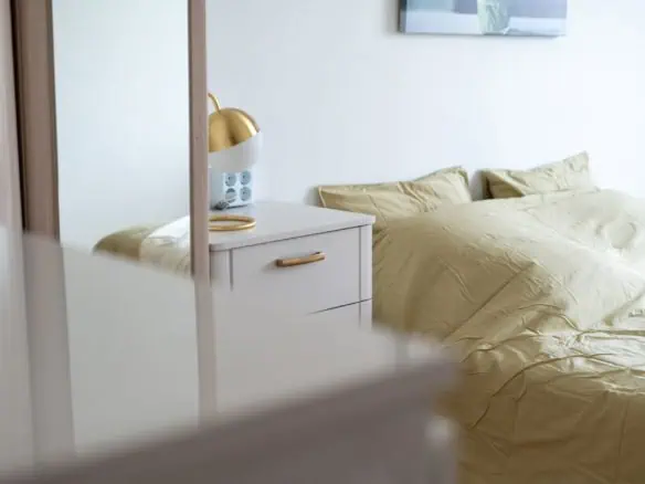 Beautiful minimalist hotel room in Tallinn with a stylish bed and modern bedside table.