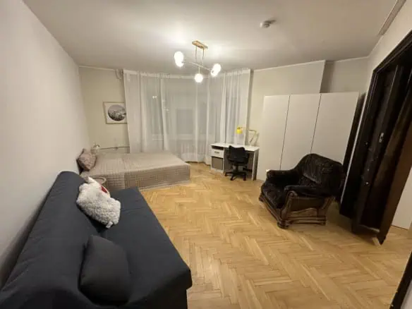 Comfortable room in Tallinn with sofa, desk, and vintage armchair.