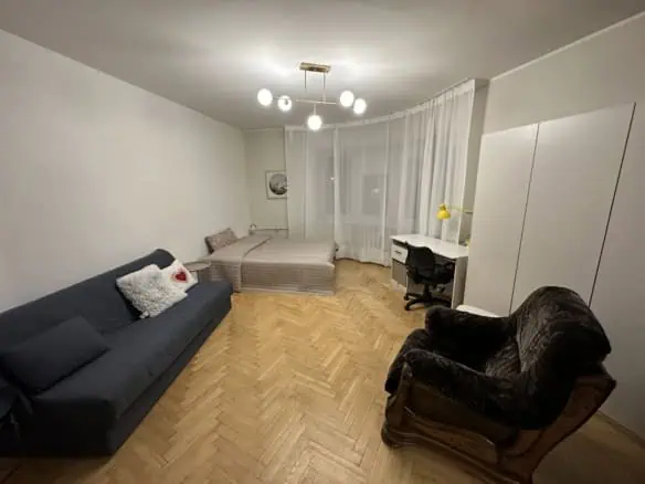 Bright, inviting living space with a sofa, armchair, bed, and study area in Tallinn.