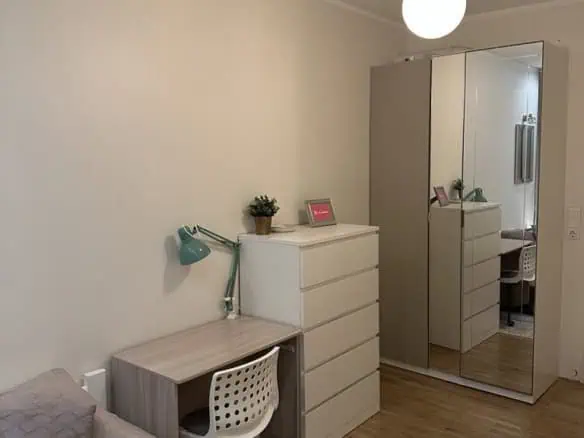Bright and modern bedroom apartment in Tallinn, featuring a desk, wardrobe, and comfortable bed. Perfect for short stays.