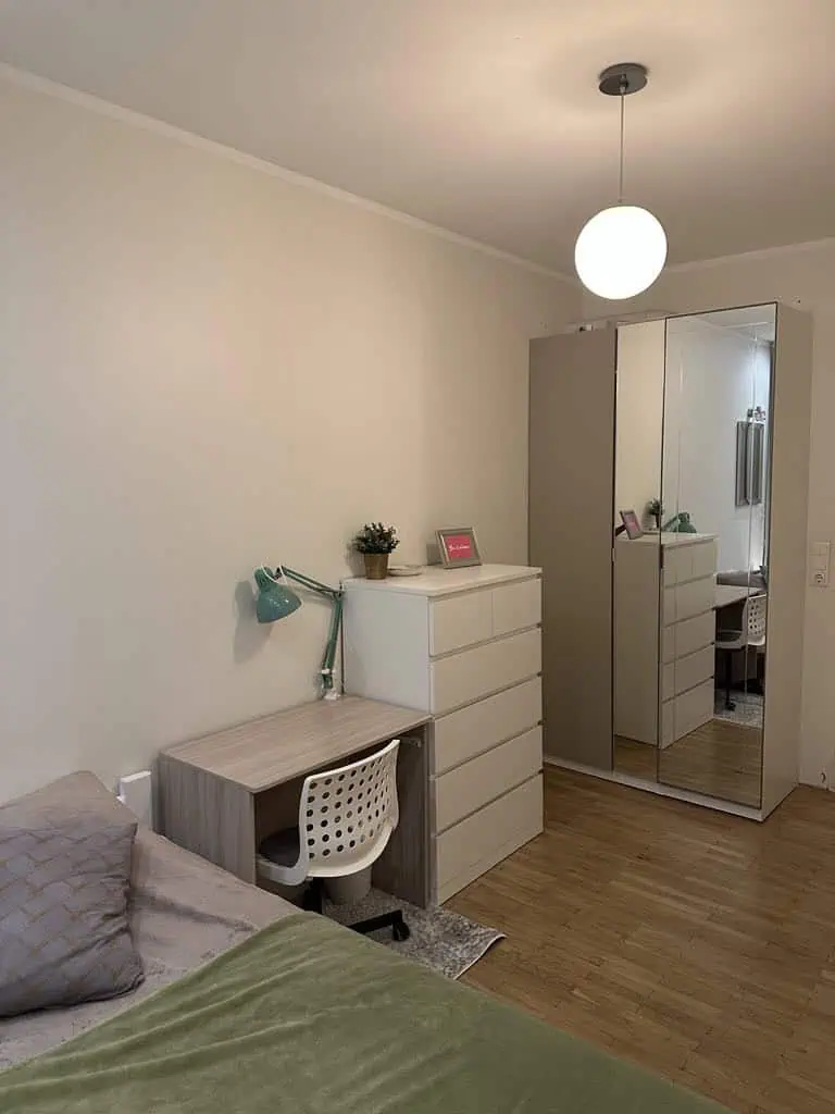 Bright and modern bedroom apartment in Tallinn, featuring a desk, wardrobe, and comfortable bed. Perfect for short stays.