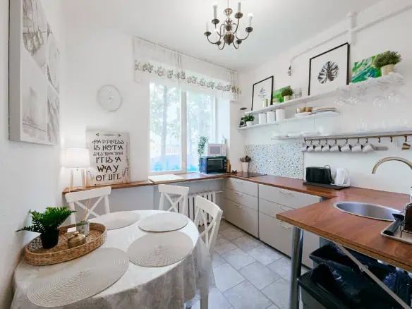 Bright and inviting kitchen in Tallinn featuring white walls, colourful accents, and sleek appliances, perfect for a comfortable stay.