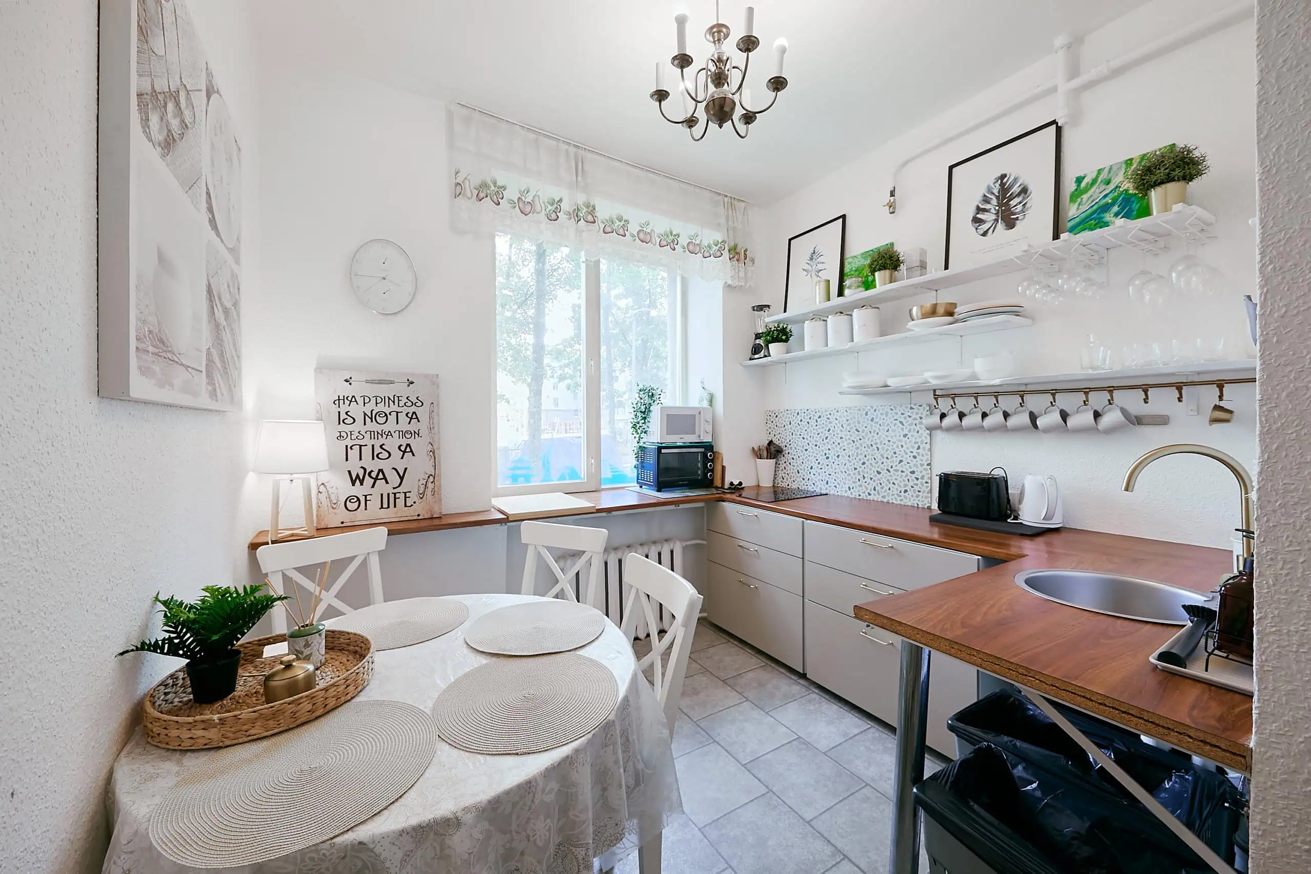 Bright and inviting kitchen in Tallinn featuring white walls, colourful accents, and sleek appliances, perfect for a comfortable stay.