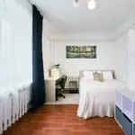 Bright hotel accommodation in Tallinn featuring a large window, stylish interior, and essential amenities.