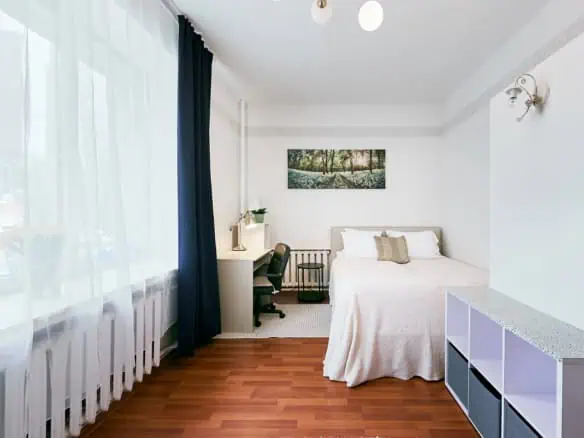 Bright hotel accommodation in Tallinn featuring a large window, stylish interior, and essential amenities.