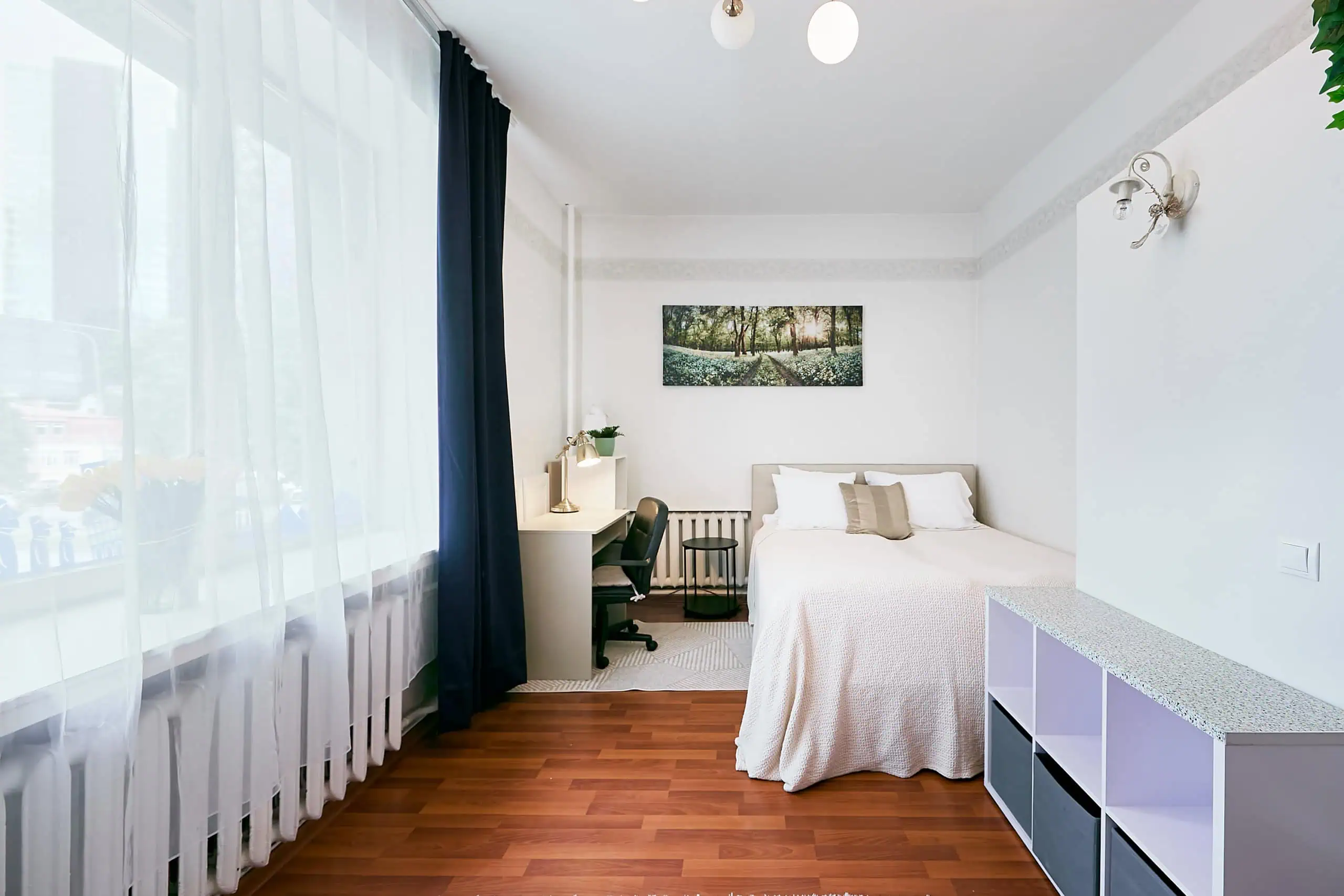 Bright hotel accommodation in Tallinn featuring a large window, stylish interior, and essential amenities.