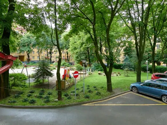 Beautiful green courtyard at Koolrooms Tallinn with trees and outdoor space.