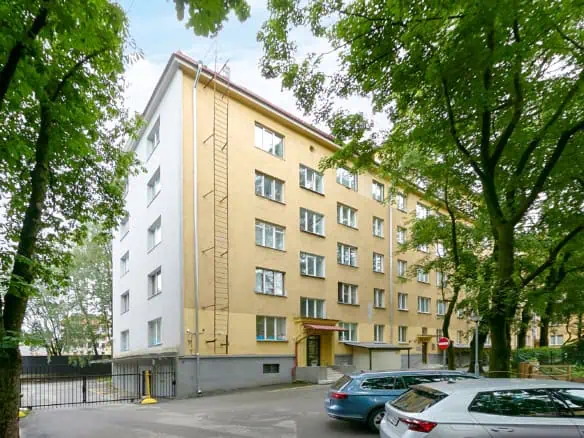 Clean, contemporary hotel façade in Tallinn with lush foliage for a peaceful atmosphere.