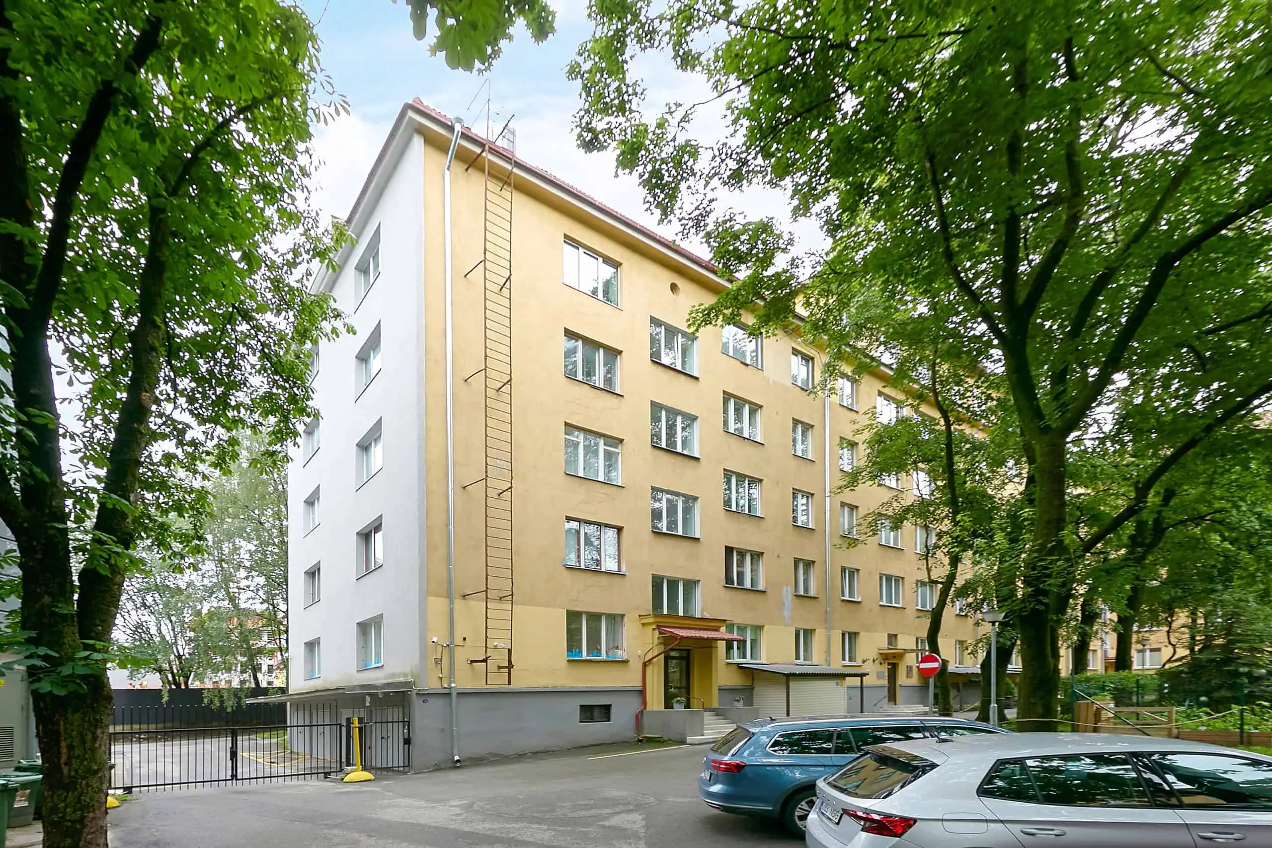Clean, contemporary hotel façade in Tallinn with lush foliage for a peaceful atmosphere.