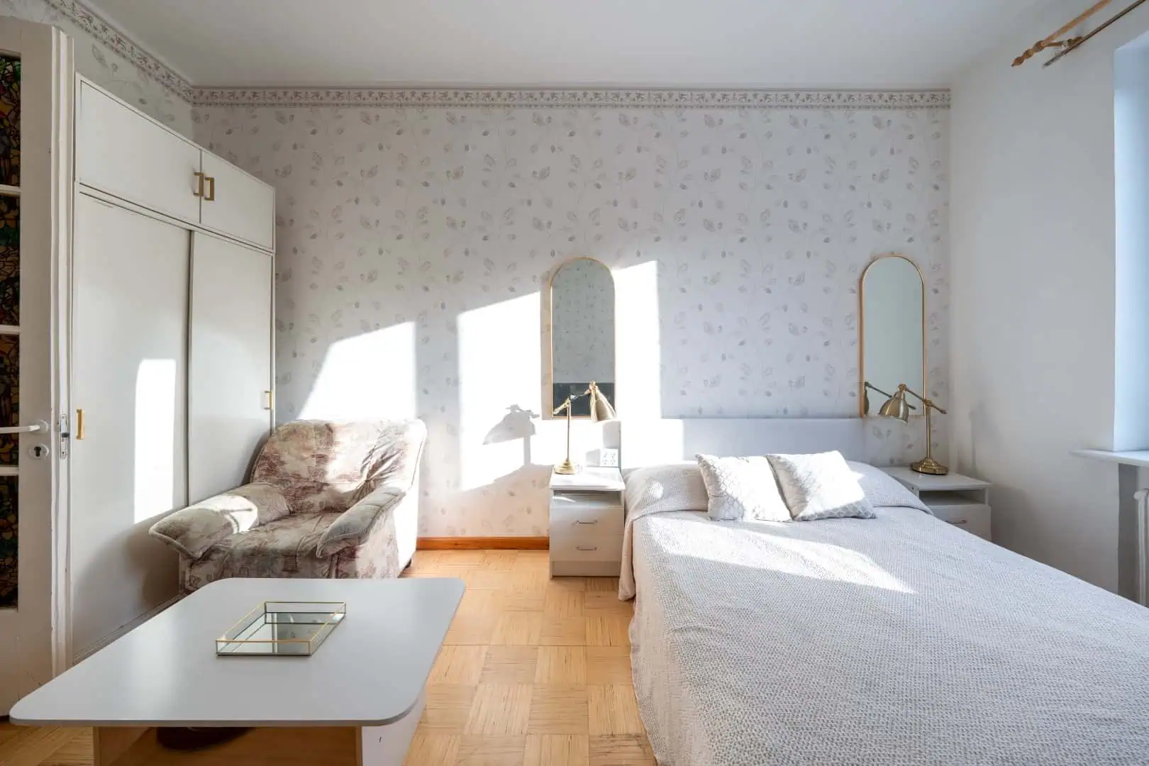 Comfortable Tallinn guest room with elegant furnishings and ample natural light, ideal for a peaceful visit.