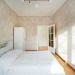 Bright shared apartment room at Koolrooms Tallinn with cosy white bedding and natural sunlight.
