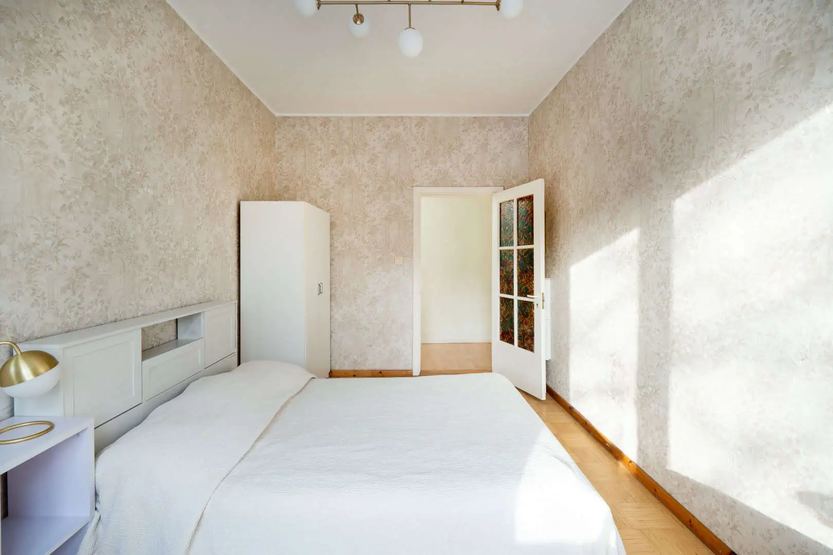 Bright hotel bedroom in Tallinn with warm tones and elegant furnishings, perfect for relaxing stays.