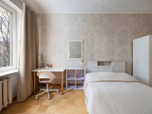Bright hotel room with a comfortable bed, desk, and large window in Tallinn, Estonia.