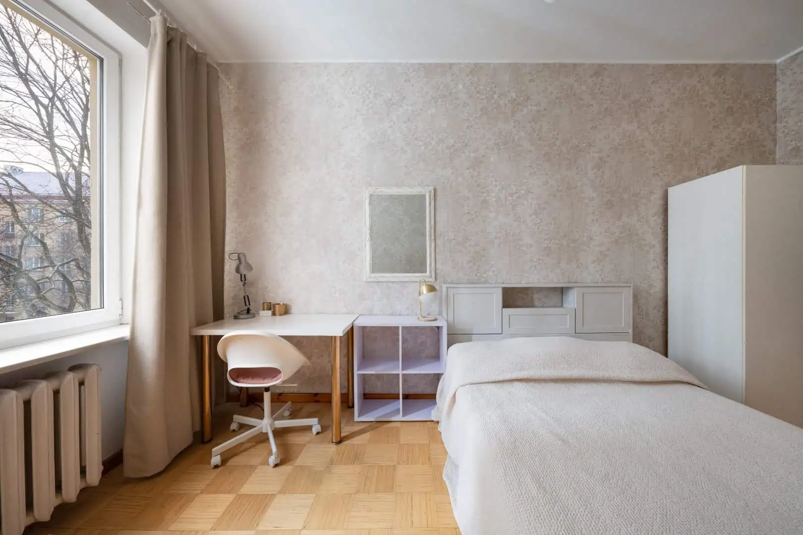 Bright hotel room with a comfortable bed, desk, and large window in Tallinn, Estonia.