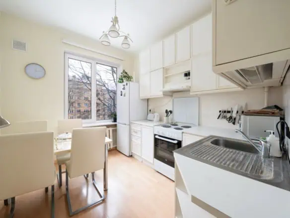 Bright kitchen in Koolrooms Tallinn apartment with modern appliances and dining area.