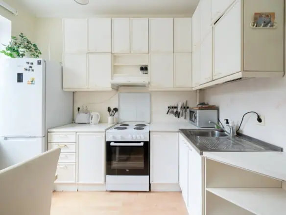 Bright white kitchen in Tallinn with modern appliances and ample storage at Koolrooms Tallinn.
