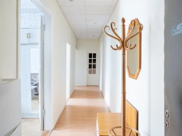 Bright corridor featuring a wooden coat rack and mirror at Koolrooms Tallinn guesthouse.