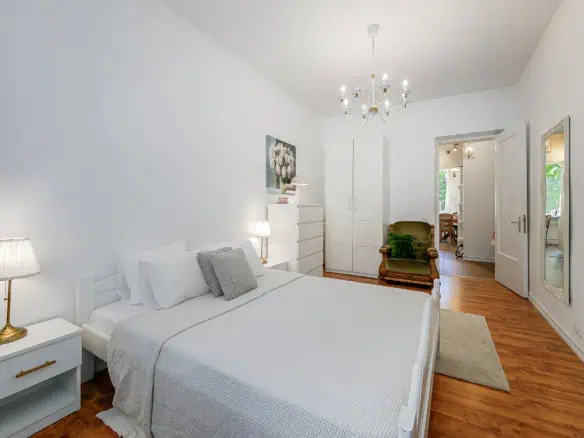 Bright and inviting bedroom with white decor, modern furniture, and stylish lighting in Tallinn.
