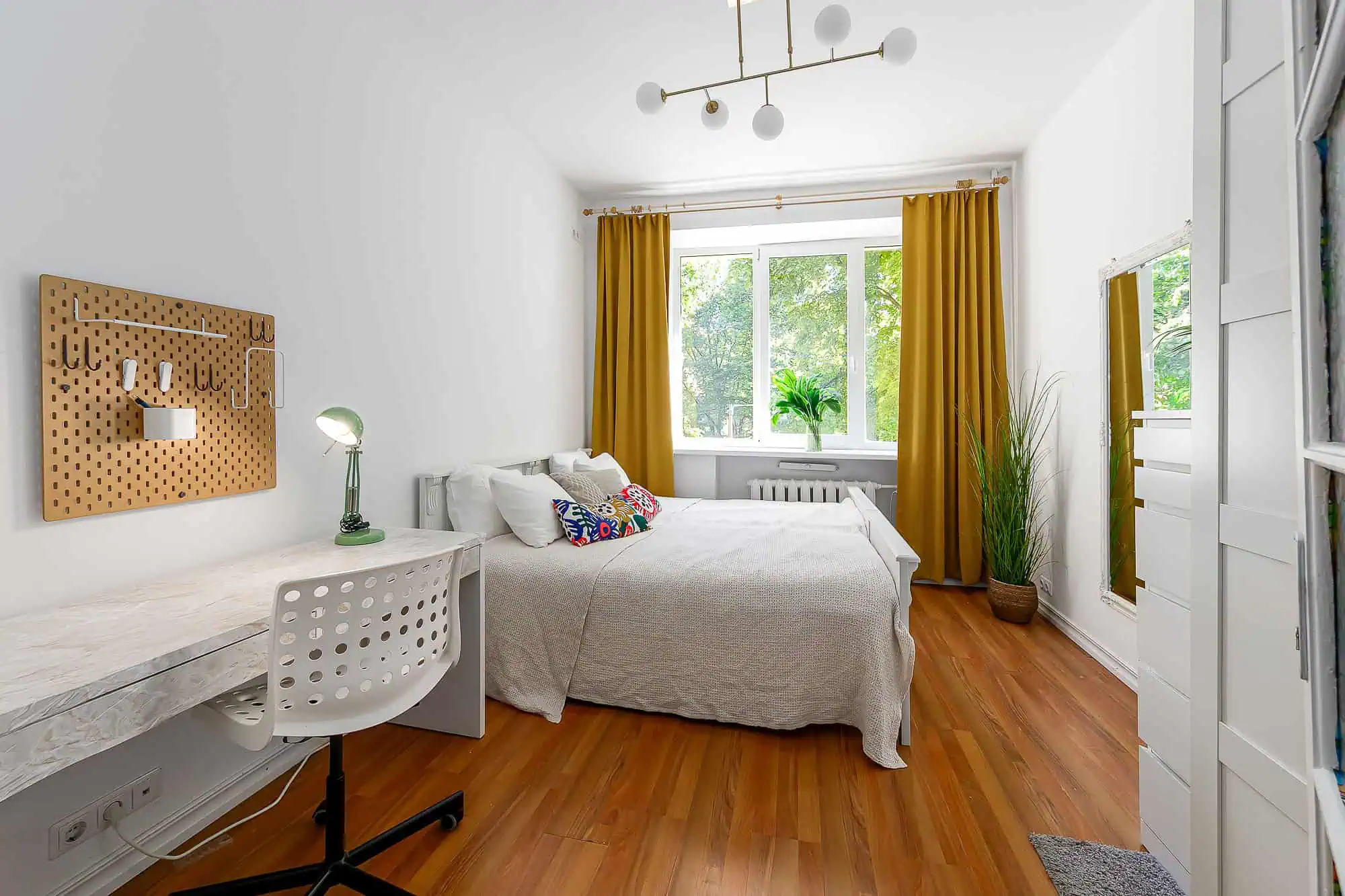 Modern Tallinn apartment with cosy bedroom and bright decor. Bright, stylish Tallinn apartment bedroom with large window, warm yellow curtains, and contemporary decor, ideal for short stays.