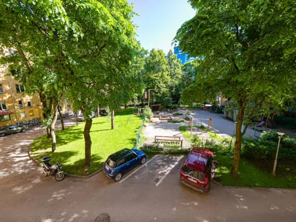 Charming Tallinn hotel parking area near lush gardens and outdoor play area.