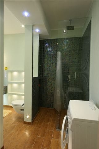 Modern Ensuite Bathroom. Spacious bathroom with walk-in shower, washing machine, and stylish finishes at Koolrooms Tallinn student apartment.
